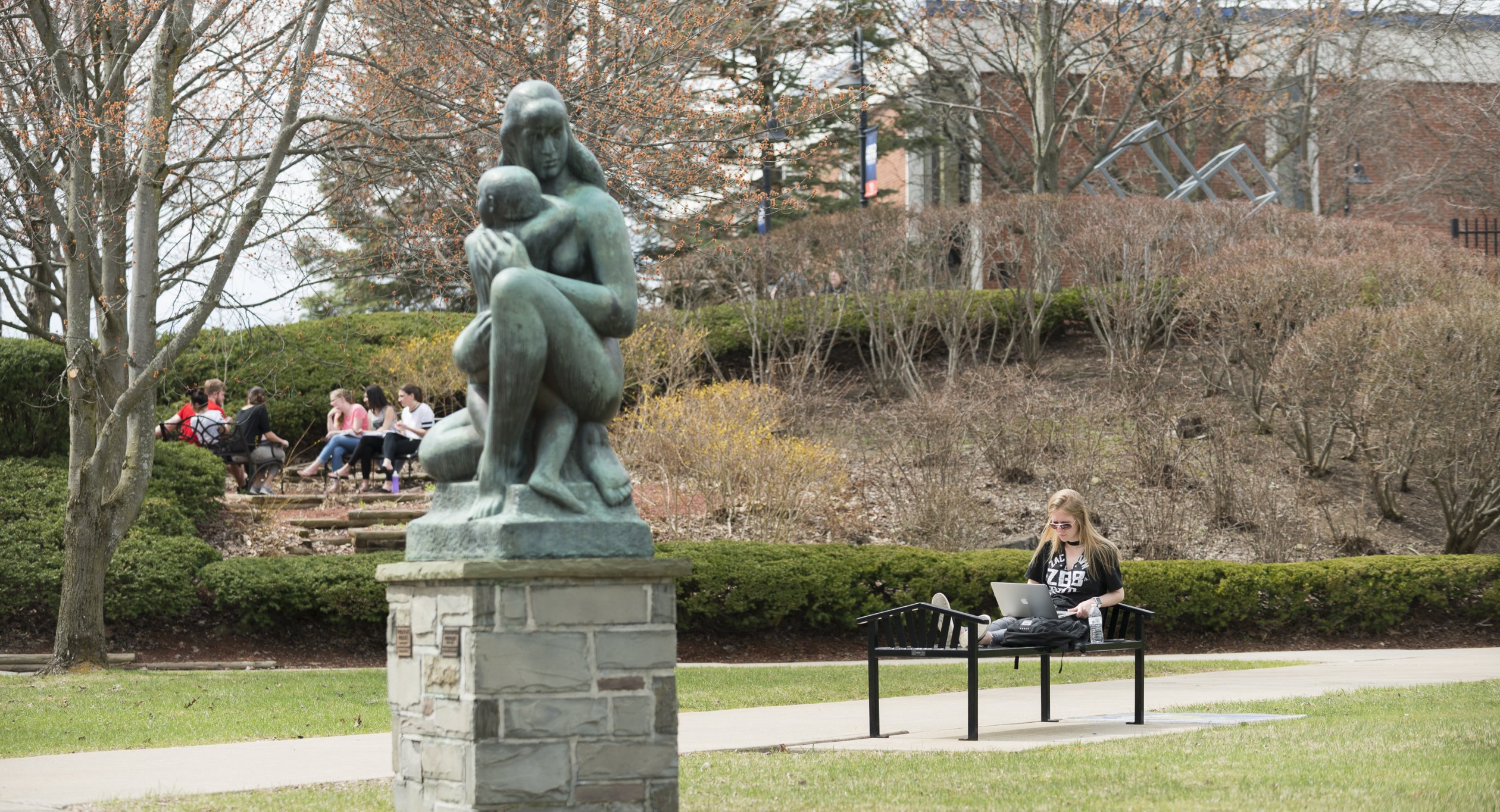 Campus Scenic Spring - Students work near statue