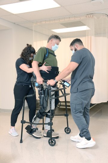 Patient in walker being assisted at Sunnyview Rehabilitation Hospital.