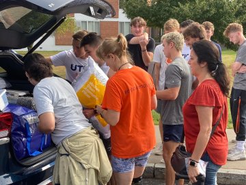 Returning Utica students help new students and families unload their cars at Move-In Day 2022.