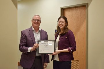 President Todd Pfannestiel stands with 2024 Francis A. Wilcox Internship recipient Corrine Bush.