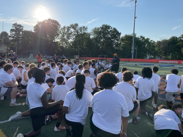 Players kneel on the field for A Call to Men Football Camp