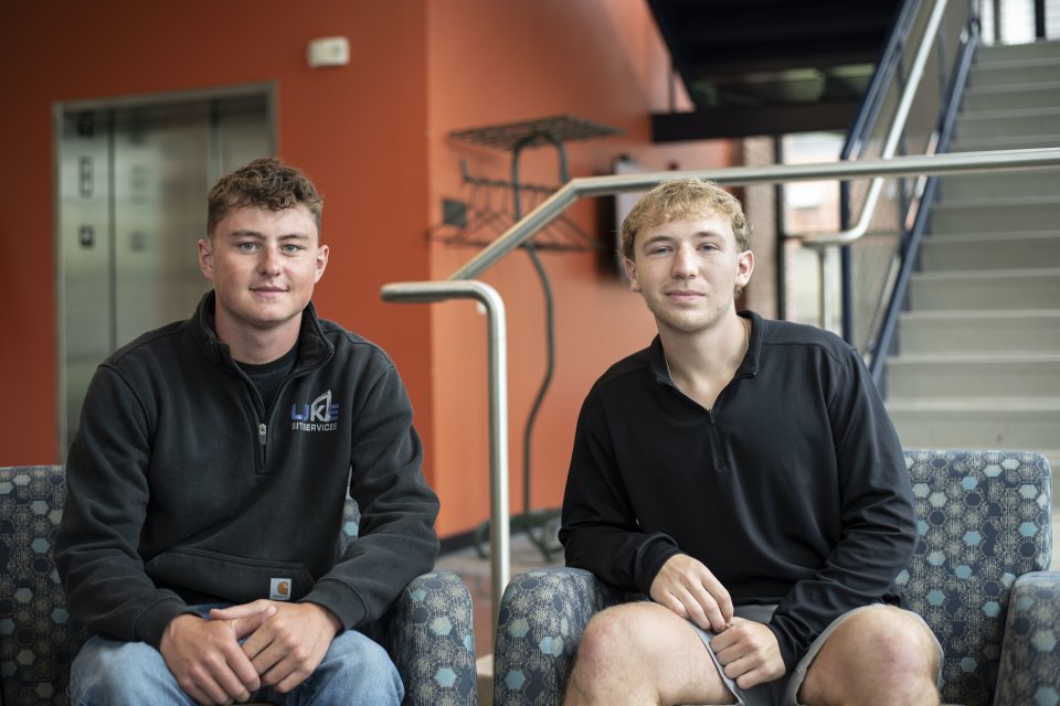 Evan Andrews ’27 and Thaddeus Luke ’27 sit on chairs. 